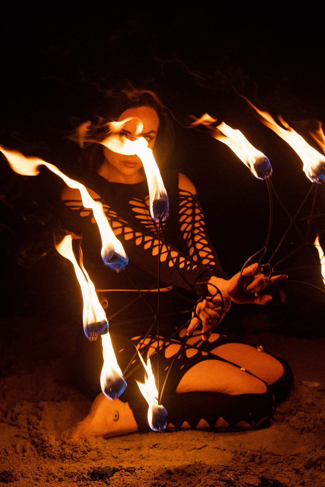 Fire performer in flame-resistant costume performing with fire